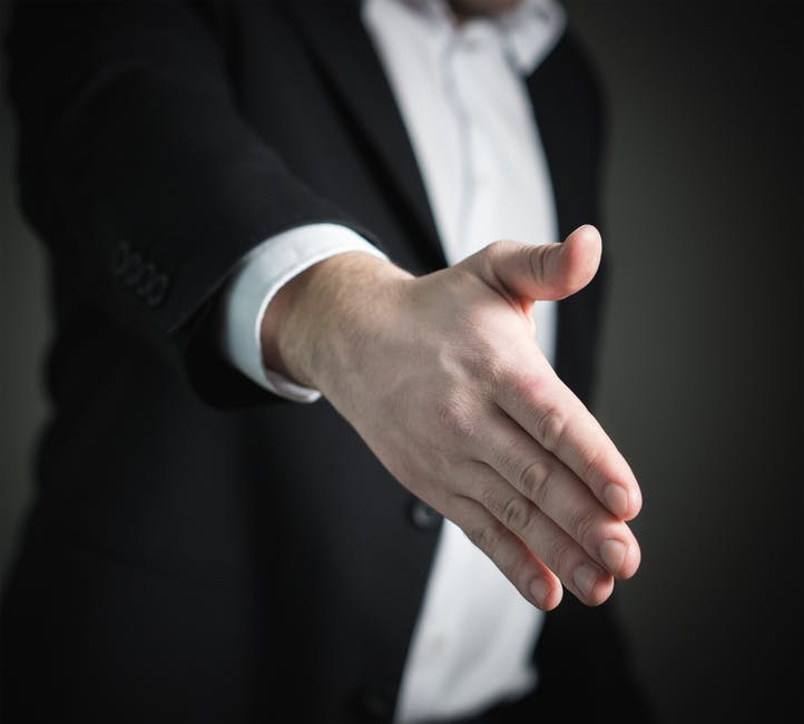 professional man reaching out to shake someone's hand